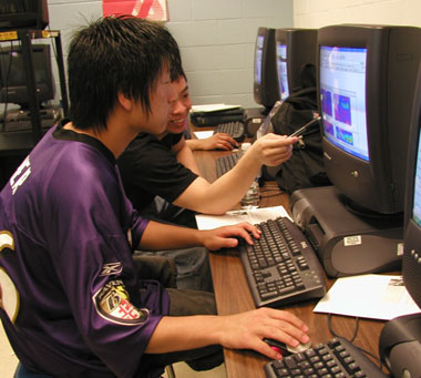 students working together and pointing at a screen from the website